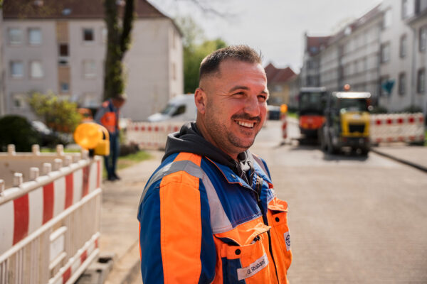 Foto: Lächelnder TL-Mitarbeiter auf der Baustelle